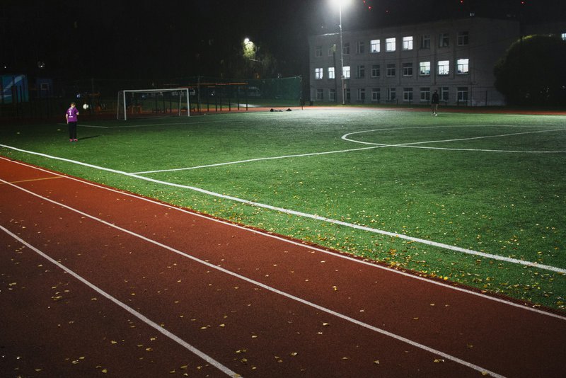 A soccer field at night with a person on it